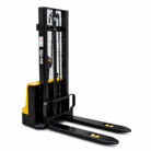 Electric pallet stacker with a tall black mast, yellow body, and two long forks extending forward for lifting and moving pallets.