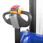 Close-up of a portable gas heater control area, with a red top, orange knob, and a blue propane tank beneath the unit.