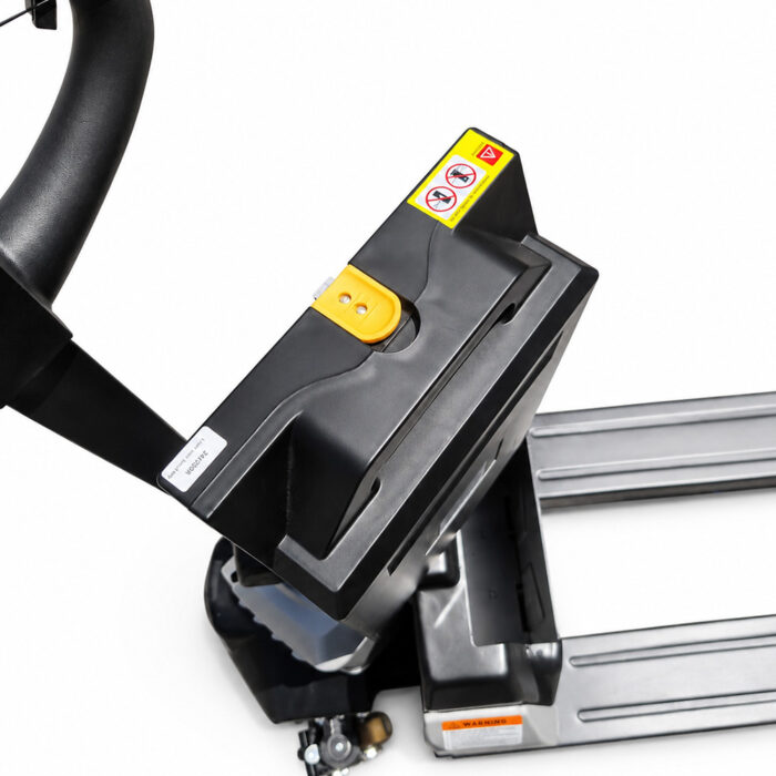Close-up of an electric pallet jack control handle with a yellow activation button and warning labels.