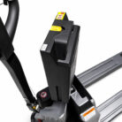 Electric pallet stacker handle and control unit with yellow safety buttons and warning labels, viewed from above