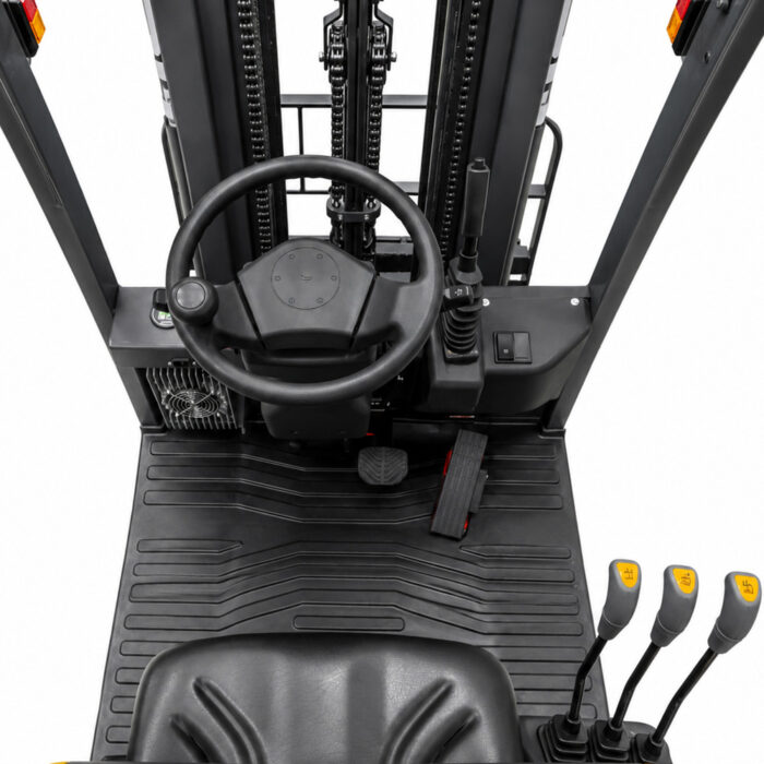 Operator-facing view in a forklift cab: steering wheel, pedal pair, and multiple joystick controls on the right, with a rugged floor mat and mast scaffolding visible in the background.