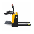 Electric pallet truck with two long forks, yellow and black body, and a standing rider platform on the left.] , ...