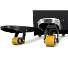Close-up of a black skateboard with yellow wheels and metal trucks included in a wheel housing at the front.