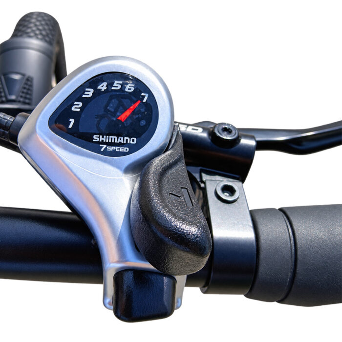 Close-up of a Shimano 7-speed bike gear shifter and handlebar grip on a bicycle.