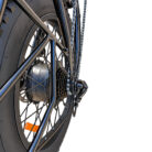 Close-up of a black bicycle rear wheel showing gears, chain, and hub with orange reflector reliefing on the spokes.