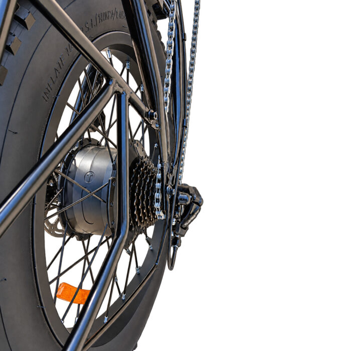 Close-up of a black bicycle rear wheel showing gears, chain, and hub with orange reflector reliefing on the spokes.