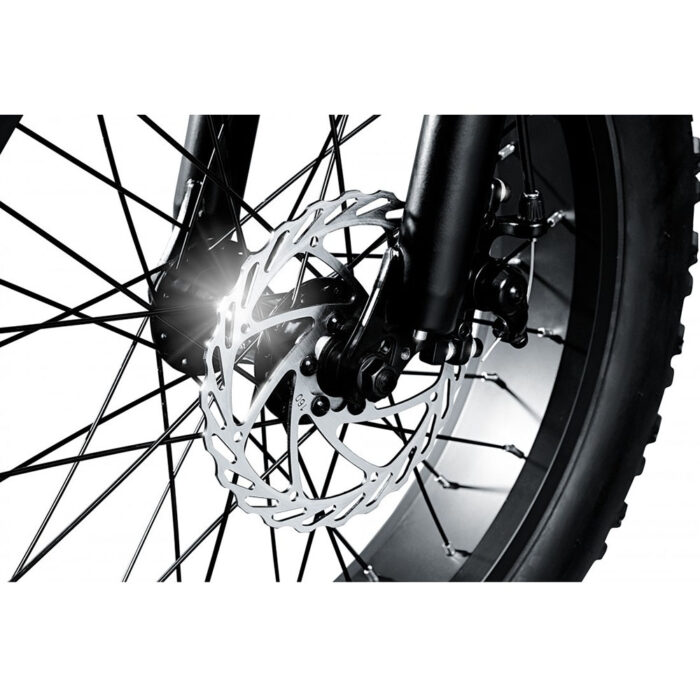 Close-up of a bicycle front wheel showing a metal disc brake rotor and spokes.